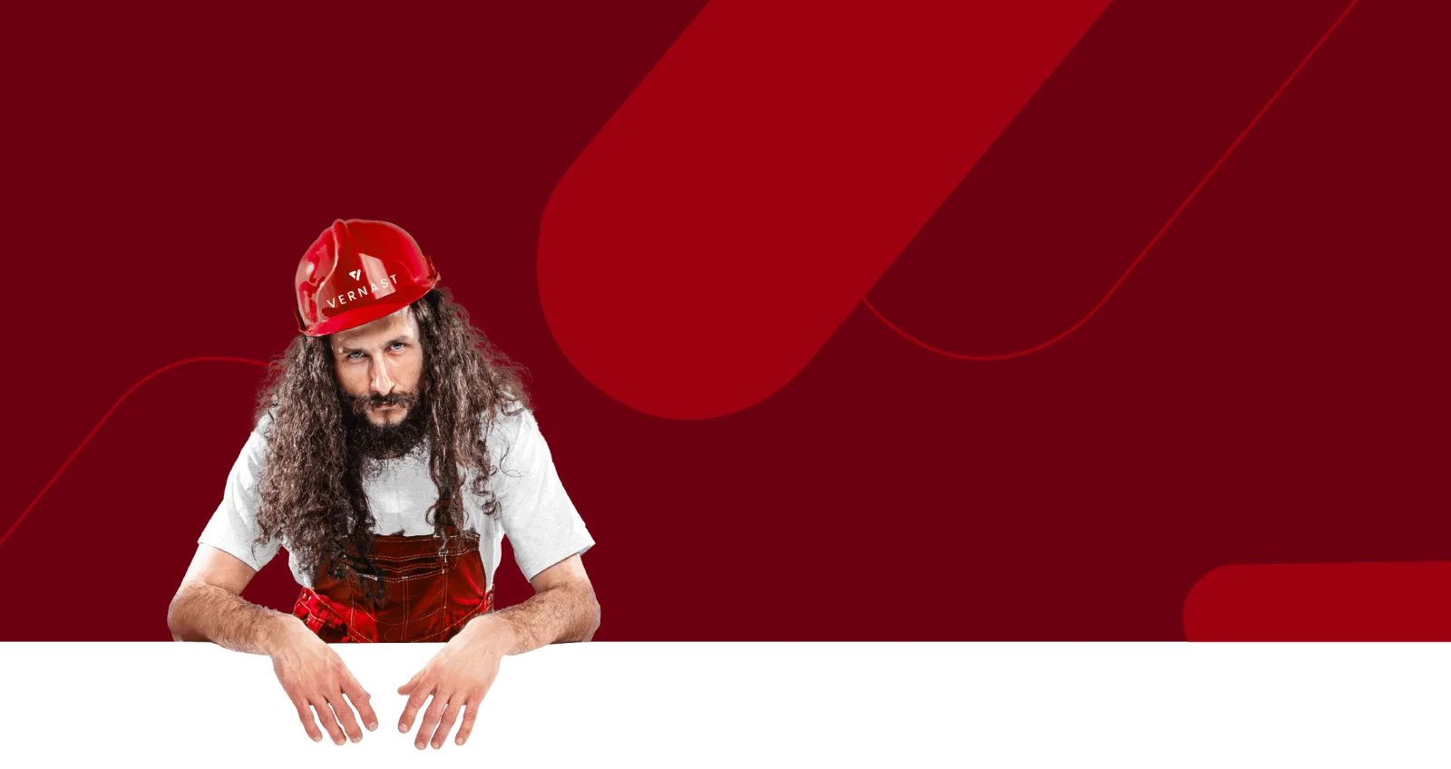 Vernast-vakman met rode helm leunt met beide handen op de rand van een rood vlak